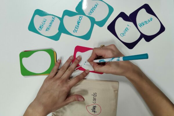someone writing on erasable play cards playful benefits of play