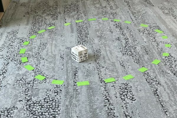 Dice on the floor surrounded by a circle made of post-it notes
