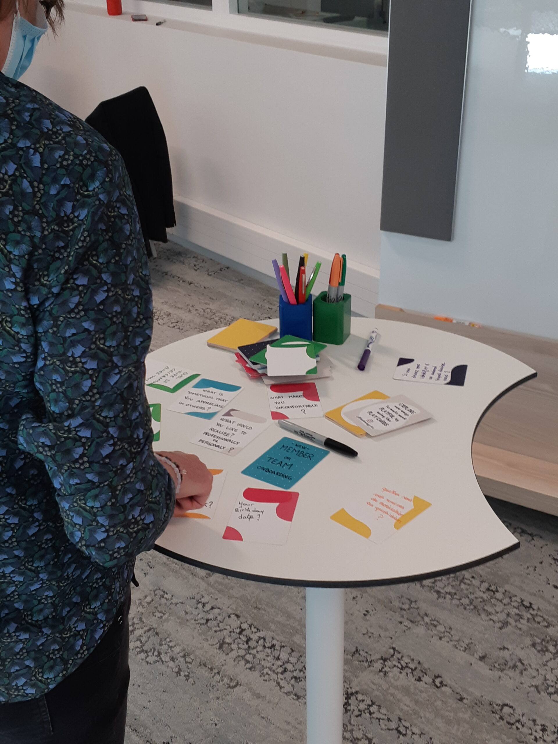 Photo d'une femme de dos utilisant nos Play Cards au cours d'une formation, mettant en évidence que nous avons une pédagogie centrée sur la mise en pratique